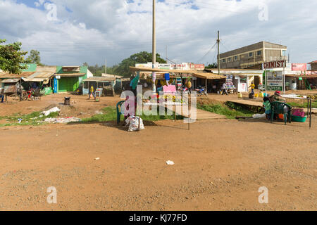 Una donna africana si distingue per la sua piccola stalla stradale per la vendita di frutta e verdura in una piccola città, Kenya, Africa orientale Foto Stock