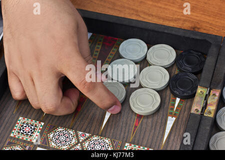 Una mano d'uomo detiene un backgammon Foto Stock