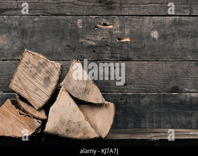 Pila di faggio legna su una rustica parete in legno con lo spazio per il tuo testo o immagine Foto Stock