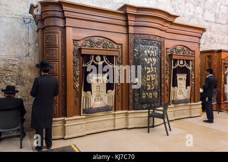 Uomini ebrei che pregano vicino a un gabinetto di legno con Torah scorre nella Sinagoga della Grotta adiacente al Muro Occidentale, la Città Vecchia, Gerusalemme, Israele Foto Stock