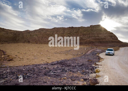 Auto che si muove su strada sterrata passando attraverso il deserto, Makhtesh Ramon, deserto di Negev, Israele Foto Stock