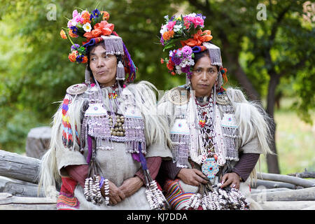Due donne Ariane nel tradizionale dressess decorato con fiori, argento e pelliccia di pecora, Dha Ristorante HANU, Ladakh, Jammu e Kashmir in India. Foto Stock