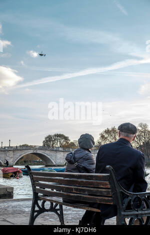 Richmond upon Thames,uk- Coppia di mezza età osservando un elicottero della polizia in bilico su Richmond bridge Foto Stock