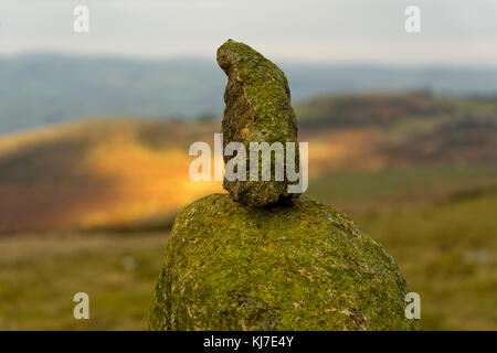 La pietra superiore di uno dei numerosi Cairns si trova sulla collina di stapeley. sun attivato attraverso le nuvole in luce i campi lontani. Foto Stock