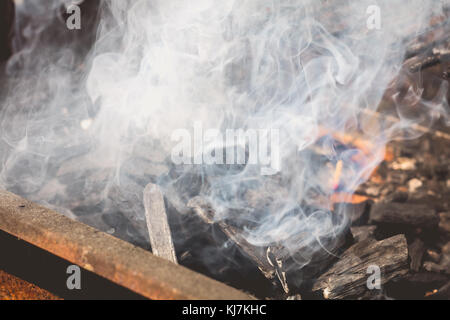 Vecchio arrugginito barbecue per la cottura a vapore quando l'illuminazione in un giardino Foto Stock