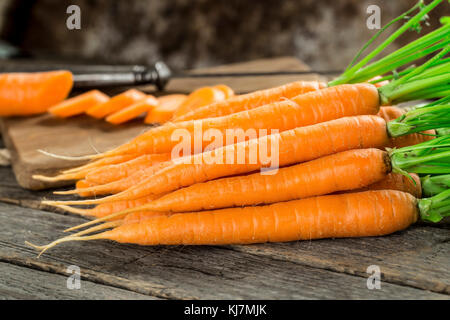 Fresco e dolce carota sul grigio di un tavolo di legno Foto Stock