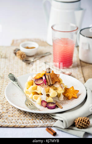 Tavolo colazione: Waffle con frutta fresca, cannella e yogurt. Vista frontale. Natale Foto Stock