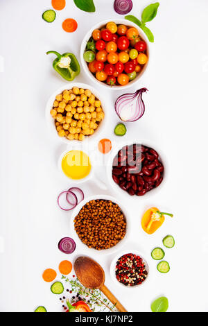 Selezione di legumi spezie erbe e verdure organiche. Ingredienti per la cottura. Cibo su sfondo bianco. Vista dall'alto uno spazio di copia. Foto Stock
