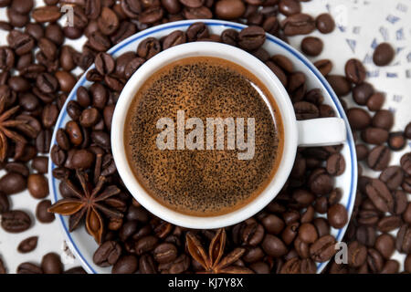 Composizione di una tazza di caffè con fagioli spalmabili e anice stellato. Foto Stock