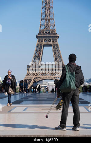 Place du Trocadero, Parigi, Francia. Gli immigrati africani vendita negozio di souvenir e di miniatura Torre Eiffel, con la vera torre Eiffel in background. Foto Stock