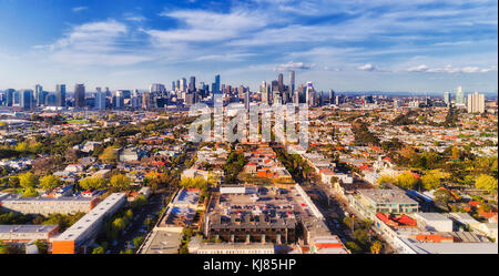 Vista aerea della città di Melbourne CBD alti torri dal porto di Melbourne e Southbank sopra sobborgo residenziale tetti delle case e strade locali, strade, ca Foto Stock