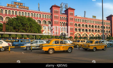 La stazione di Howrah e' un antico edificio architettonico coloniale a Kolkata con vista del traffico cittadino e dei famosi taxi gialli della citta'. Foto Stock