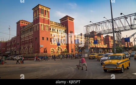La stazione di Howrah e' un antico edificio architettonico coloniale a Kolkata con vista del traffico cittadino e dei famosi taxi gialli della citta'. Foto Stock