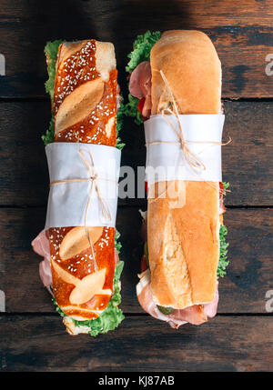 Sommergibile panini con le verdure e il prosciutto su sfondo di legno con uno spazio vuoto Foto Stock