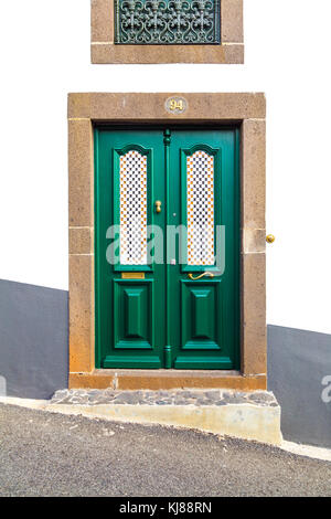 Un unico verde decorativo porta a una casa su una strada in pendenza a Funchal, Madeira, Portogallo Foto Stock