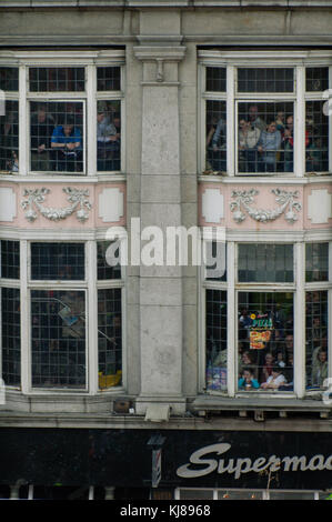 Persone in windows guardare irlandese forze militari parade presso il 1916 Pasqua Rising commemorazione marciando attraverso il centro della città di Dublino Irlanda Foto Stock