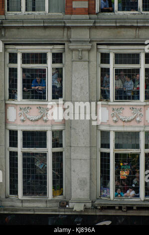 Persone in windows guardare irlandese forze militari parade presso il 1916 Pasqua Rising commemorazione marciando attraverso il centro della città di Dublino Irlanda Foto Stock