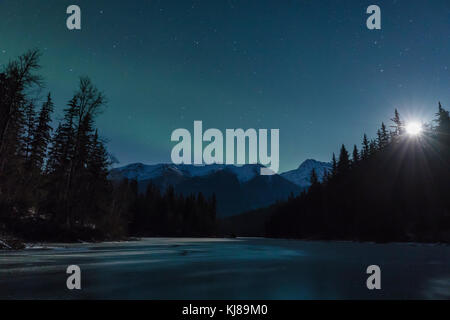 L'aurora borealis e la luna crescente sopra il lago di zanzara vicino Haines nell'Alaska sud-orientale. Foto Stock