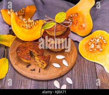 Muffin di zucca e i pezzi di zucca freschi su un sfondo di legno Foto Stock