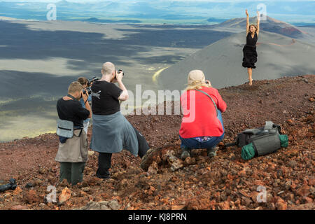 Un gruppo di fotografi scatta un modello sulla cima del sentiero escursionistico, sali fino all'eruzione nord della grande fessura di Tolbachik 1975 Foto Stock