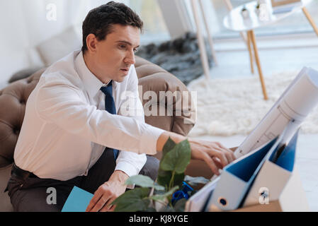 Calma uomo serio controllo della sua cose personali dopo essere licenziato Foto Stock