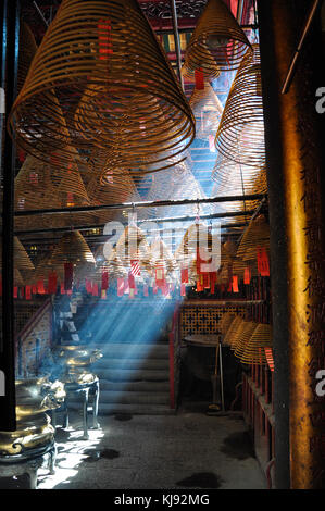 Versando la luce del sole attraverso il fumo di incenso di un tempio a hong kong Foto Stock