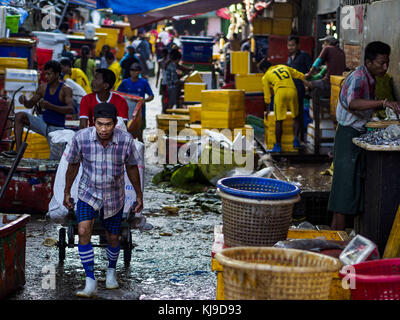 Yangon, regione di Yangon, Myanmar. 23 nov, 2017. Un operaio invia ghiaccio in san al contrario PYA il mercato del pesce. san al contrario PYA il mercato del pesce è uno dei più grandi mercati del pesce in Yangon. Si tratta di una 24 Ore di mercato, ma più trafficati di mattina presto. La maggior parte dei pesci nel mercato è selvaggio catturato ma l'acquicoltura è in espansione in Myanmar e di allevamento più pesci di acqua dolce viene venduto adesso che in passato. Credito: jack kurtz/zuma filo/alamy live news Foto Stock