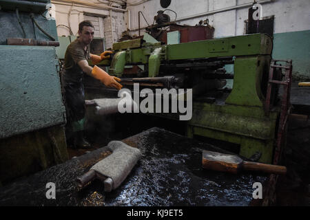 6 dicembre 2016 - Syktyvkar, Repubblica di Komi, Russia - l'operaio ha visto fare forma agli stivali di lana. La produzione di calzature tradizionali russe fatte di lana presso la fabbrica di calzature di lana Vylgort. La fabbrica di calzature in lana Vylgort produce calzature da oltre 75 anni. (Immagine di credito: © Sergey Parshukov/SOPA tramite filo ZUMA) Foto Stock