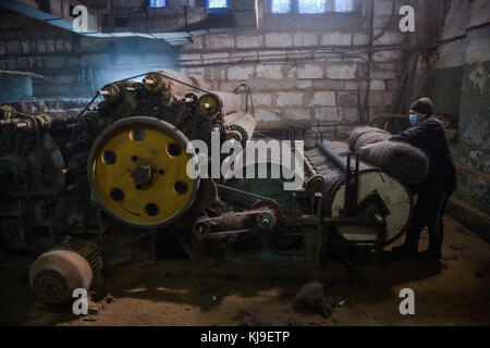 6 dicembre 2016 - Syktyvkar, Repubblica di Komi, Russia - il lavoratore diffonde la lana attraverso la macchina..la produzione di calzature tradizionali russe fatte di lana presso la fabbrica di calzature di lana Vylgort. La fabbrica di calzature in lana Vylgort produce calzature da oltre 75 anni. (Immagine di credito: © Sergey Parshukov/SOPA tramite filo ZUMA) Foto Stock