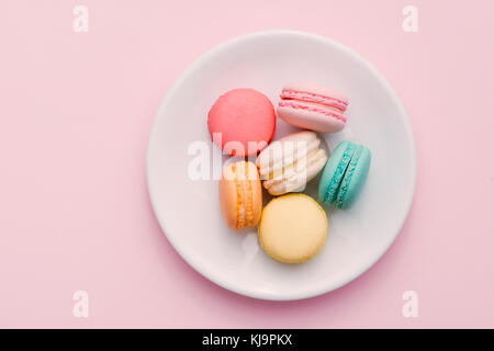 In casa colorata amaretti o macaron sulla piastra bianca Foto Stock