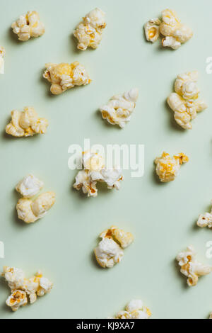 Il popcorn nel bicchiere di carta su sfondo verde. Foto Stock