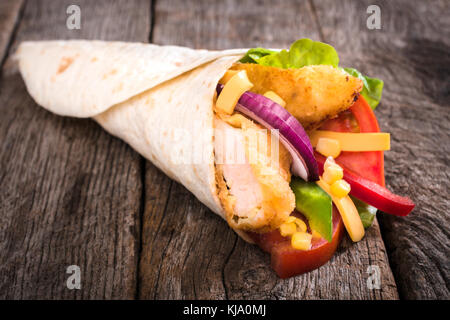 Tortilla panini con fritto di pollo e verdure su sfondo di legno,fuoco selettivo Foto Stock