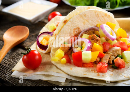 Tradizionale Tortilla messicana pane farcito con carne e verdure sul tavolo.Il fuoco selettivo sulla parte anteriore tortilla Foto Stock