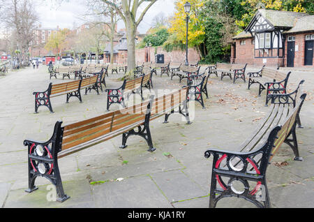 Panchine deserte sui solchi di fronte al palco per spettacoli sulle rive del fiume Dee in Chester in un freddo giorno di autunno Foto Stock