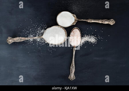 Tre antichi cucchiai d'argento riempita con una varietà di sali, rosa himalayan, sale marino e sale da tavola. Foto Stock