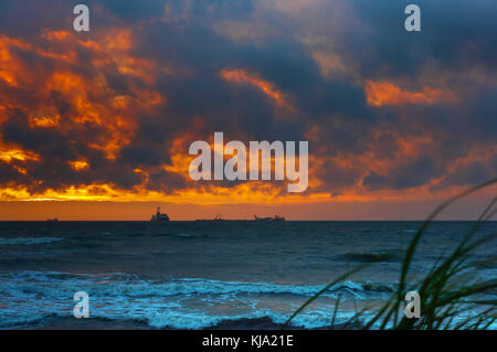 Tramonto sul mare. Riflesso della luce solare nelle onde del mare. Cielo rosso nei raggi del tramonto. Foto Stock