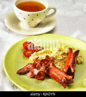 Prima colazione Inglese con uova strapazzate, pancetta e salsicce Foto Stock