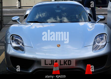 Una Porsche 918 spyder parcheggiato a Genova, di fronte a uno yacht. Foto Stock