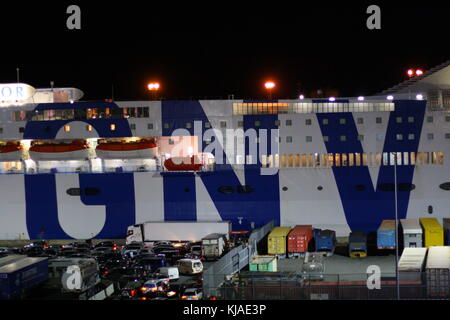Un gigantesco traghetto GNV Lines nel porto di Genova, in Italia, di notte, pronto a salpare verso l'acqua di mare aperto. Foto Stock