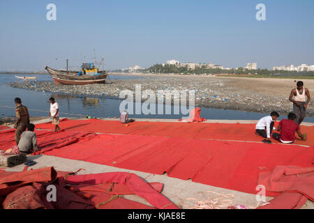 Persone che lavorano sul tessile fuori a Khar Danda a Mumbai, India Foto Stock