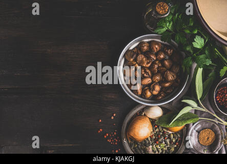 Arrosto di castagne sbucciate con ingredienti per la gustosa cucina stagionale su scuro dello sfondo rustico, vista dall'alto, il luogo per il testo Foto Stock