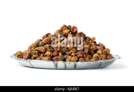 Granuli di propoli all'interno della piastra sullo sfondo, prodotto delle api Foto Stock