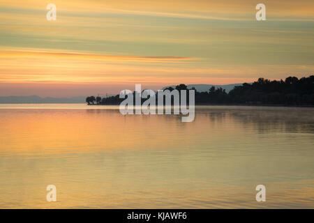 Prima del Sunrise il colorato cielo è riflessa nei dolci increspature di un mare calmo. Foto Stock