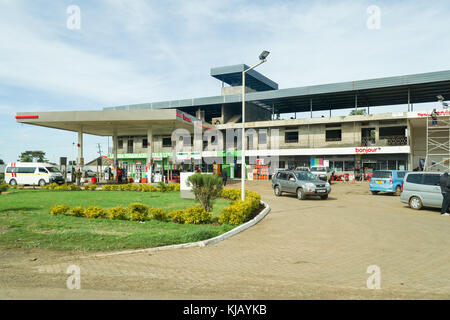 Un totale di stazione di benzina con edifici in costruzione dietro di essa e i clienti e i veicoli nel piazzale antistante, Kenya, Africa orientale Foto Stock