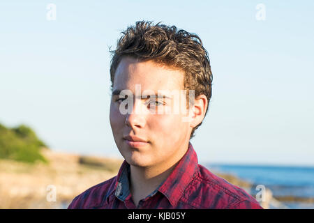 Bel Giovane Uomo in camicia, mare in background Foto Stock