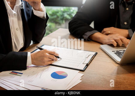 Imprenditore team che lavora in ufficio e utilizzando un computer digitale portatile mani dettaglio, computer e oggetti sul tavolo Foto Stock