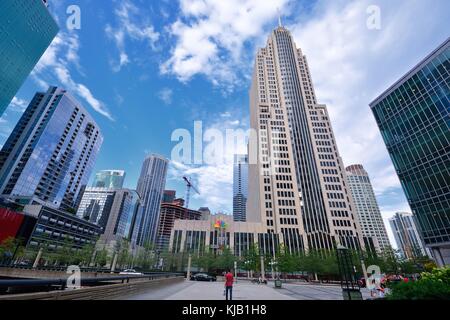 Chicago, Illinois, 15 luglio 2017: Tipica scena di strada, nel centro di Chicago. Un giovane uomo che indossa il rosso si sposta a casa tra grattacieli. Foto Stock