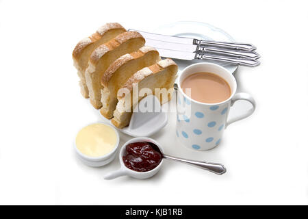 White toast fette in ceramica rack toast con burro e marmellata di rosso, la tazza di tè e piatti da portata e i coltelli su sfondo bianco. Foto Stock