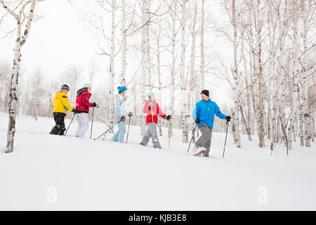 Famiglia caucasica escursioni con le racchette da neve Foto Stock