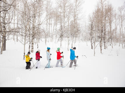 Famiglia caucasica escursioni con le racchette da neve Foto Stock